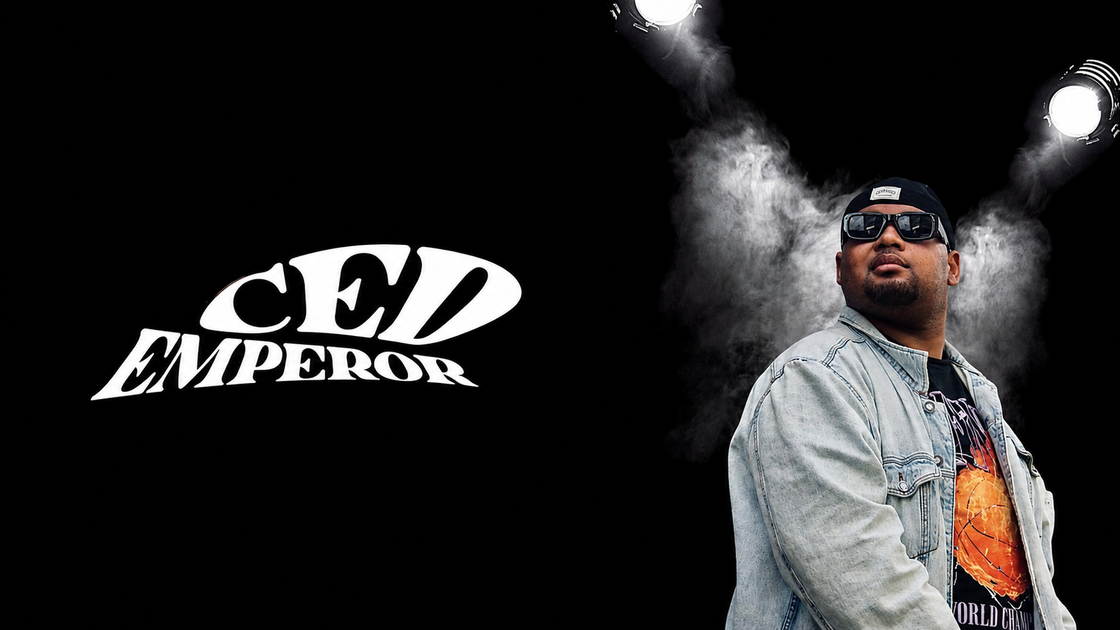 CED Emperor en veste en jean, sous les projecteurs, avec sa signature blanche sur fond noir